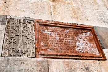ancient carved armenian letters in inscriptions on stone wall of medieval geghard monastery in Armenia