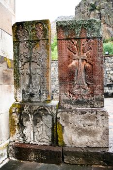carved cross on ancient stone tombs of medieval geghard monastery in Armenia