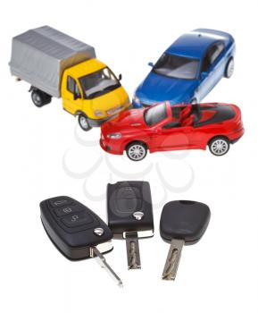 three vehicle keys close up and model cars isolated on white background