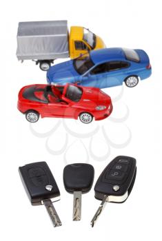 three vehicle keys and model cars isolated on white background