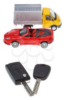 two vehicle keys close up and model truck and car isolated on white background