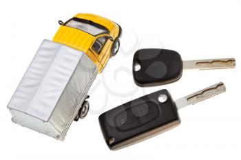above view of two vehicle keys and truck model isolated on white background