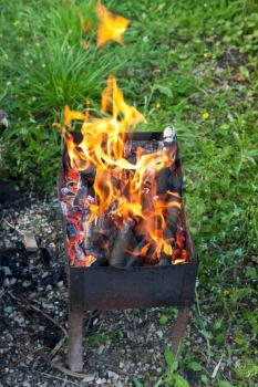fire flames over burning wood in outdoor brazier
