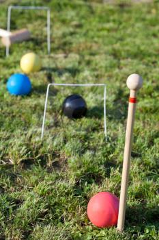 four balls in game of croquet on green lawn in summer day