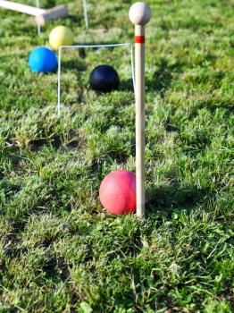 four balls on grass in game of croquet on green lawn in summer day