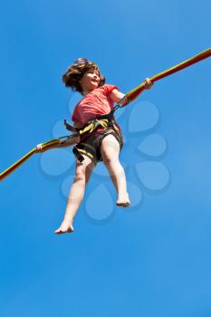 girl on bungee cord with blue sky background