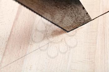 wooden plank is cut with hacksaw close up