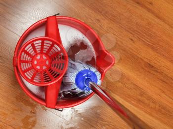 top view of mop in bucket with water for housecleaning