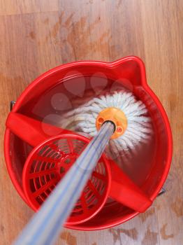 top view of textile mop in water in red bucket
