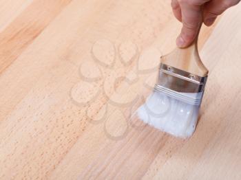 varnishing of surface of beech table top by paint brush