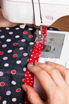seamstress sews clothing on sewing machine close up