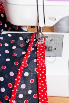 sewing dress on sewing machine close up