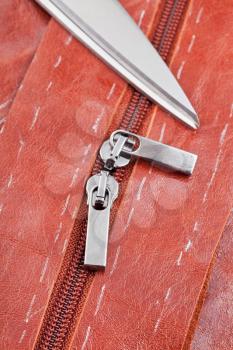 tailor shears and zip runners on details of brown leather pattern
