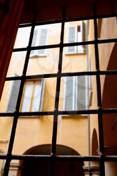 view through window iron bars on italian urban house court