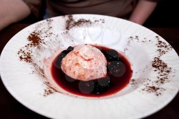 sweet cream dessert panna cotta with wild berry sauce in italian restaurant