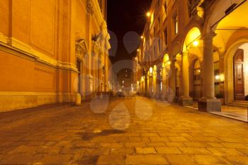 portico and facade of st peter cathedral on via Altabella in Bologna, Italy at night
