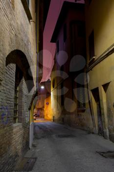 narrow medieval street in Bologna at night, Italy