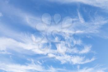 several swirling small white clouds in italian blue sky in autumn