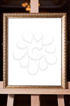wooden gold picture frame with white cut out canvas on easel