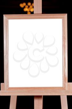 wooden picture frame with white cut out canvas on easel