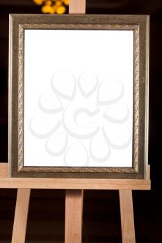 wooden old picture frame with white cut out canvas on easel