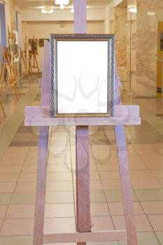 classic picture frame with white cut out canvas on easel in art gallery