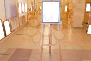 silver picture frame with white cut out canvas on easel in art gallery hall