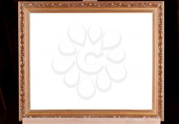 classic brown wood picture frame with white cut out canvas on easel with black background