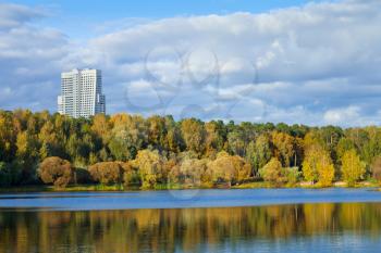 cityscape with autumn urban park on river bank afternoon