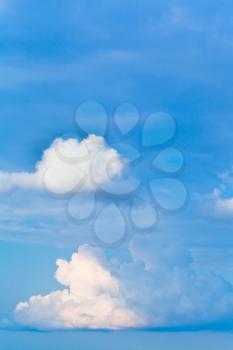 two white cumulus clouds in blue afrernoon sky