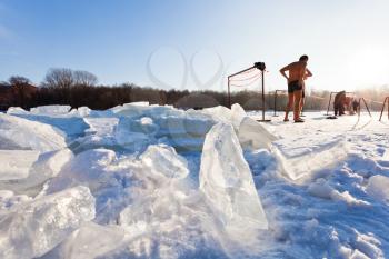 winter swimmers on frozen river in cold sunny day