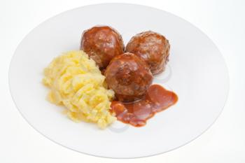 roasted meatballs under meat sauce and mashed potato on plate isolated on white background