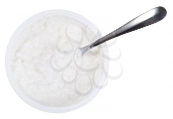 metal spoon in tub of cottage cheese isolated on white background