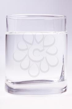 glass of clear water on grey background