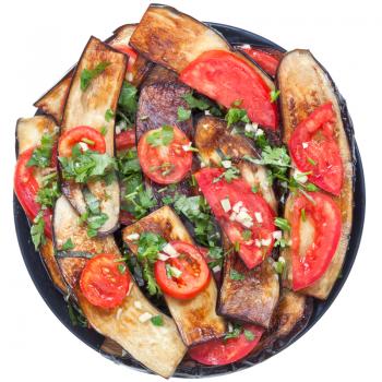 fried eggplants with red tomato and garlic on black plate isolated with white background
