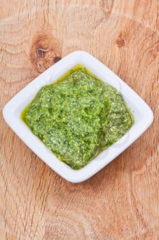 white saucer with fresh pesto on wooden board