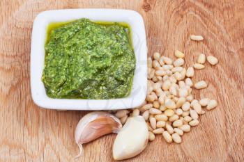 italian pesto sauce with pine nuts and garlic cloves on wood board