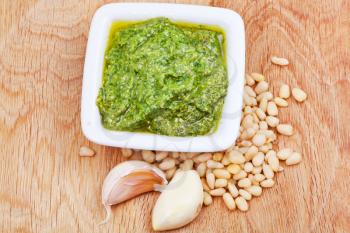 italian pesto with pine nuts and garlic cloves on wooden board