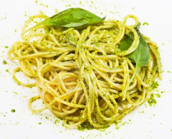 spaghetti mixed with pesto on plate isolated on white background