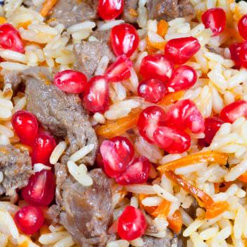 background from asian pilaf with pomegranate seeds close up