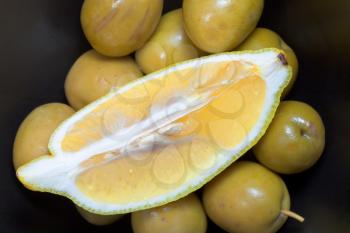 segment of fresh lemon on green olives close up