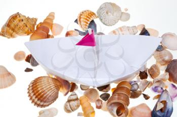hand made paper boat on background from sea shells
