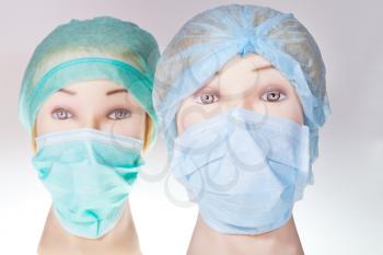 two women's manikin doctor heads wearing textile surgical cap and medical protective mask