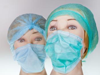 two female manikin doctor heads wearing textile surgical cap and medical protective mask