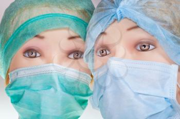 two female mannequin doctor heads wearing textile surgical cap and medical protective mask close up