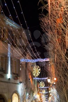 electric christmas garlands in european town at night