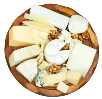 above view of wooden plate with various cheeses isolated on white background