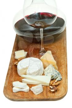 portion of cheeses and glass red wine on wooden board isolated on white background