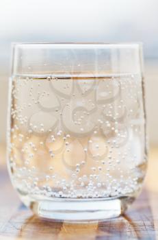 glass of spring mineral water with gas bubbles close up