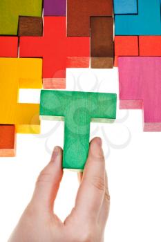 arrangement T-shaped block in wooden multicoloured puzzle isolated on white background
